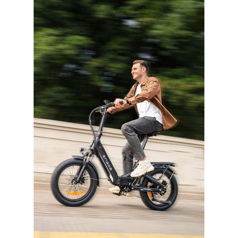 Rider on the Engwe L20 3.0 Boost in black, cycling along a paved path with rear rack visible