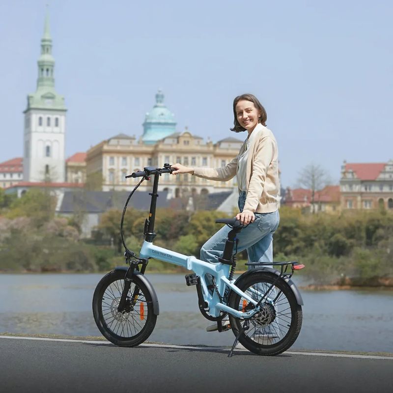 Rider standing with ADO Air 20 Pro in blue by a riverside with city skyline